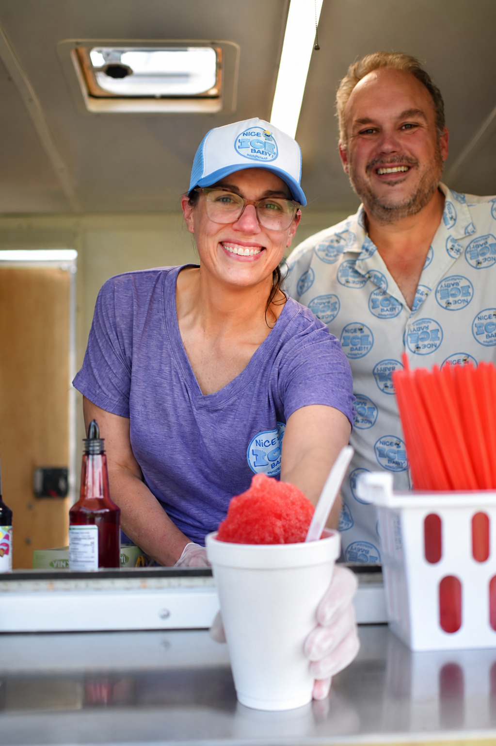 Nice Ice Baby owners serving a fresh red snowcone from the truck window